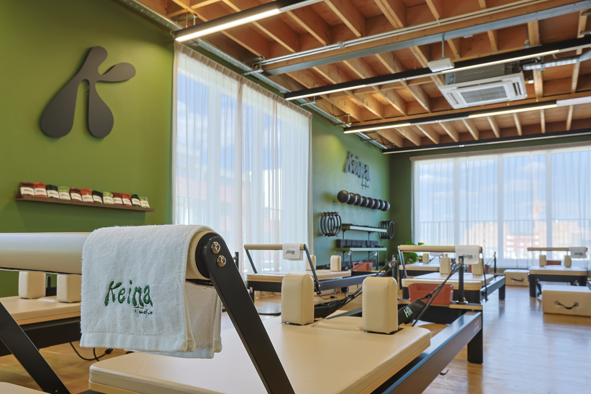 KEINA branded towel on a reformer with grip socks on the wall