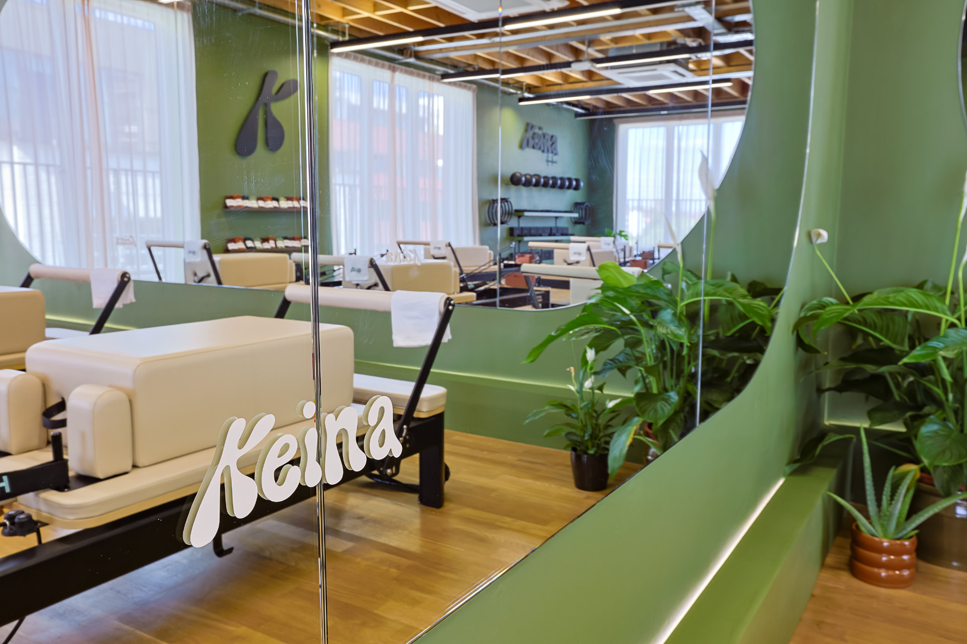 Reformers and plants seen through the KEINA glass entrance